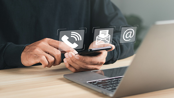 Businessman using a laptop and smartphone showing icons